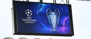 Logo a trofej UEFA Champions League zobrazená na veľkoplošnej obrazovke na štadióne San Siro v Miláne