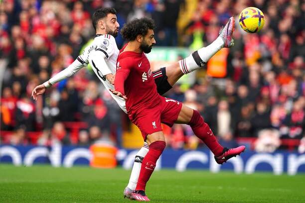 Záložník Manchesteru United Bruno Fernandes (vľavo) a útočník Liverpoolu FC Mohamed Salah v súboji o loptu