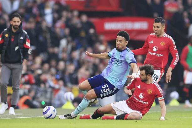 Bruno Fernandes (Man Utd) v súboji s Ethanom Nwanerim (Arsenal).