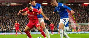 Útočník Liverpoolu Mohamed Salah (v červenom drese) v opatere obrancov Evertonu Jamesa Tarkowskiho a Vitaliya Mykolenka (vpravo) počas posledného vzájomného zápasu Liverpool vs. Everton v sezóne Premier League 2024/25