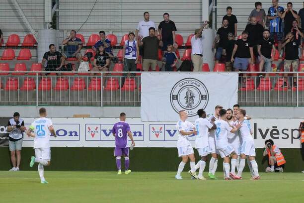 Hráči Slovana oslavujú gól na ihrisku Komárna v prvom kole Niké ligy 2024/2025. Hráči Slovana oslavujú gól na ihrisku Komárna v prvom kole Niké ligy 2024/2025.
