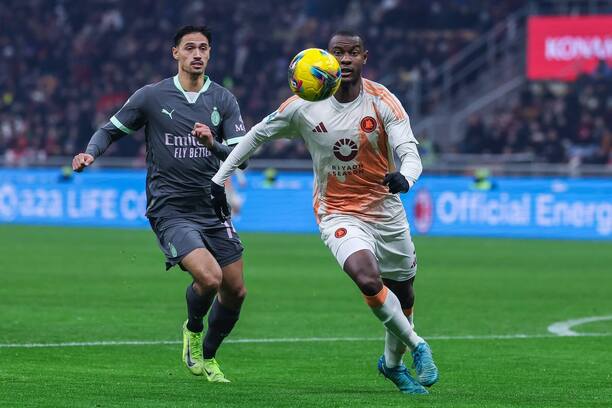 Sprava obranca AS Rím Evan Ndicka stíhaný jedným z hráčov Milána počas zápasu AC Miláno vs. AS Rím na štadióne San Siro v 18. kole Serie A 2024/25