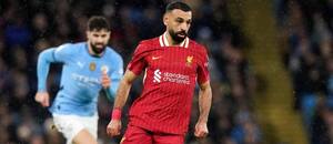 V popredí s loptou útočník Liverpoolu Mohamed Salah sledovaný jedným z hráčov Manchestru City počas zápasu Manchester City vs. Liverpool FC v 26. kole Premier League 2024/25