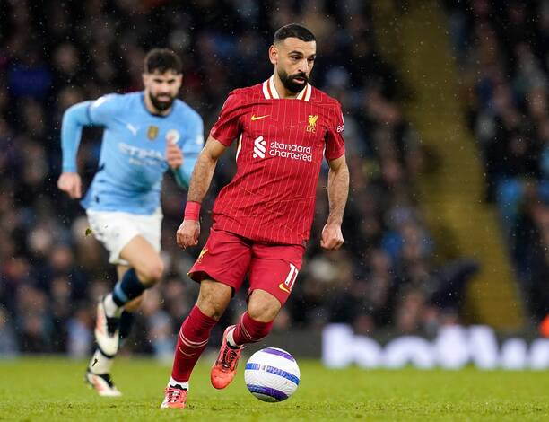 V popredí s loptou útočník Liverpoolu Mohamed Salah sledovaný jedným z hráčov Manchestru City počas zápasu Manchester City vs. Liverpool FC v 26. kole Premier League 2024/25