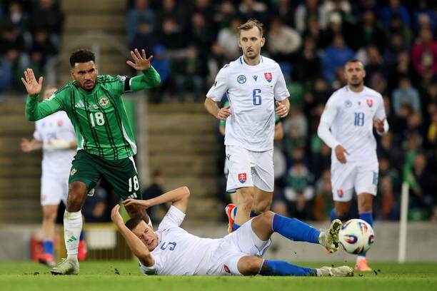 Súboj na zemi ležiaceho obrancu Slovenska Ľubomíra Šatku a útočníka Severného Írska Jamieho Reida (vľavo), v pozadí Norbert Gyombér a napravo Ivan Schranz počas zápasu Severné Írsko vs. Slovensko v Belfaste v kvalifikácii na MS vo futbale 2026