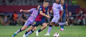 Zľava obranca Bilbaa Inigo Lekue v snahe zastaviť záložníka Barcelony Fermína Lópeza počas zápasu FC Barcelona vs. Athletic Bilbao v 2. kole La Ligy 2024/25