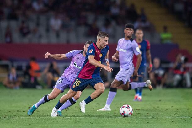 Zľava obranca Bilbaa Inigo Lekue v snahe zastaviť záložníka Barcelony Fermína Lópeza počas zápasu FC Barcelona vs. Athletic Bilbao v 2. kole La Ligy 2024/25