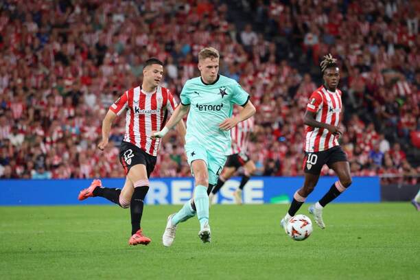 Obranca Slavie David Zima (v strede) stíhaný pravým bekom Bilbaa Jesúsom Aresom (vľavo) počas zápasu Athletic Bilbao vs. SK Slavia Praha v 3. kole Európskej ligy UEFA 2024/2025. V pozadí sleduje akciu hviezda baskického klubu Nico Williams