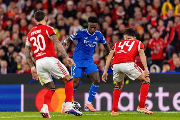 Krídelník Realu Madrid Vinicius Júnior (uprostred) proti dvom hráčom Benficy v zápase SL Benfica vs. Real Madrid CF v rámci 1. zápasu predkola osemfinále Ligy majstrov UEFA 2025/2026