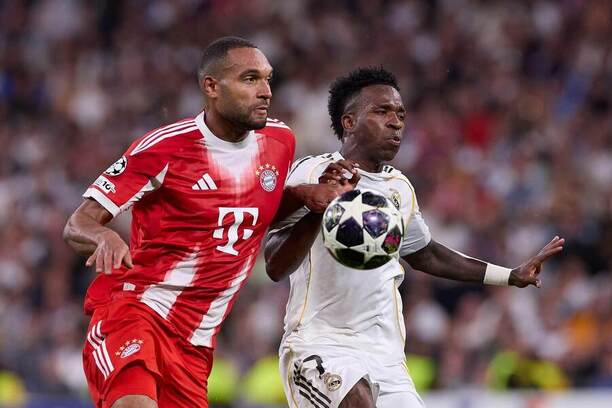 V súboji o loptu zľava obranca Bayernu Jonathan Tah a krídelník Realu Madrid Vinicius Júnior počas zápasu Real Madrid CF vs. FC Bayern Mníchov v prvom kole štvrťfinále Ligy majstrov UEFA 2025/2026