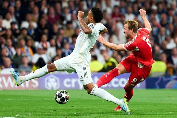 Obranca Realu Madrid Éder Militão (vľavo) v snahe zlokovať strelu útočníkovi Bayernu Harrymu Kaneovi počas prvého štvrťfinálového zápasu Real Madrid CF vs. FC Bayern Mníchov v Lige majstrov 2025/2026