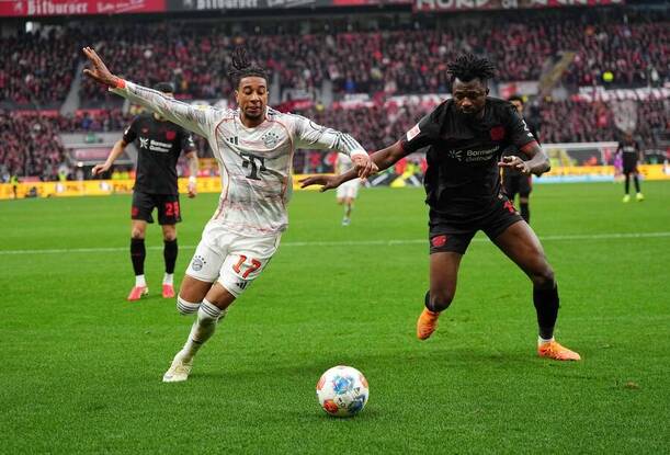 Leverkusen vs. Bayern. Na fotke Edmond Tapsoba (Leverkusen) a&nbsp;Michael Olise (Bayern).