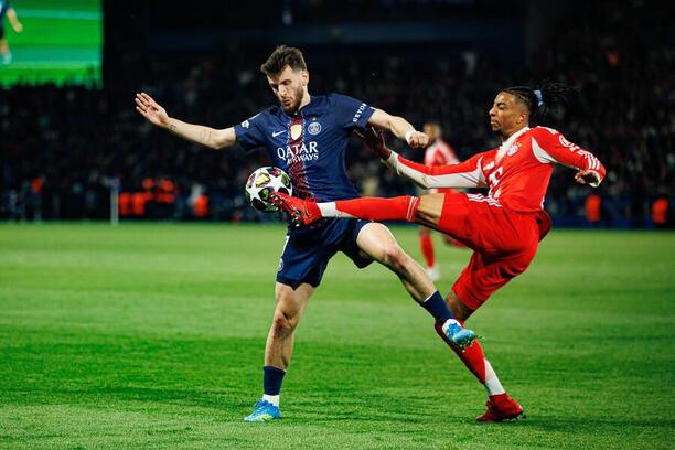 Zľava Khvicha Kvaratskhelia z PSG a Michael Olise z Bayernu v súboji krídelníkov počas prvého semifinálového zápasu Paris Saint-Germain FC vs. FC Bayern Mníchov v Lige majstrov 2025/2026