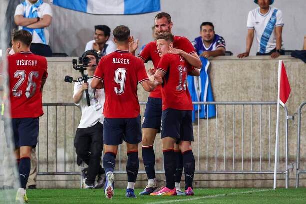 Českí futbalisti oslavujú gól.