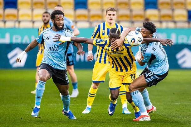 V popredí uprostred krídelník DAC Alioune Sylla v&nbsp;obkolesení obrancu Slovana Sandra Cruza (vľavo) a&nbsp;jeho spoluhráča zo&nbsp;stredu poľa Rahima Ibrahima počas aprílového zápasu FC DAC 1904 Dunajská Streda vs. ŠK Slovan Bratislava vo&nbsp;štvrtom kole skupiny o&nbsp;titul Niké ligy 2025/2026