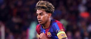 Šprintujúci útočník FC Barcelona Lamine Yamal s kapitánskou páskou na drese.