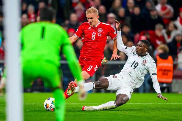 Dánsky pravý krídelník Gustav Isaksen (uprostred) a&nbsp;ľavý obranca Portugalska Nuno Mendes (vpravo) počas prvého zápasu Dánsko vs. Portugalsko vo&nbsp;štvrťfinále Ligy národov 2024/2025